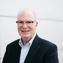 A headshot of Bill Yoder, an old, bald, white man wearing a suit.