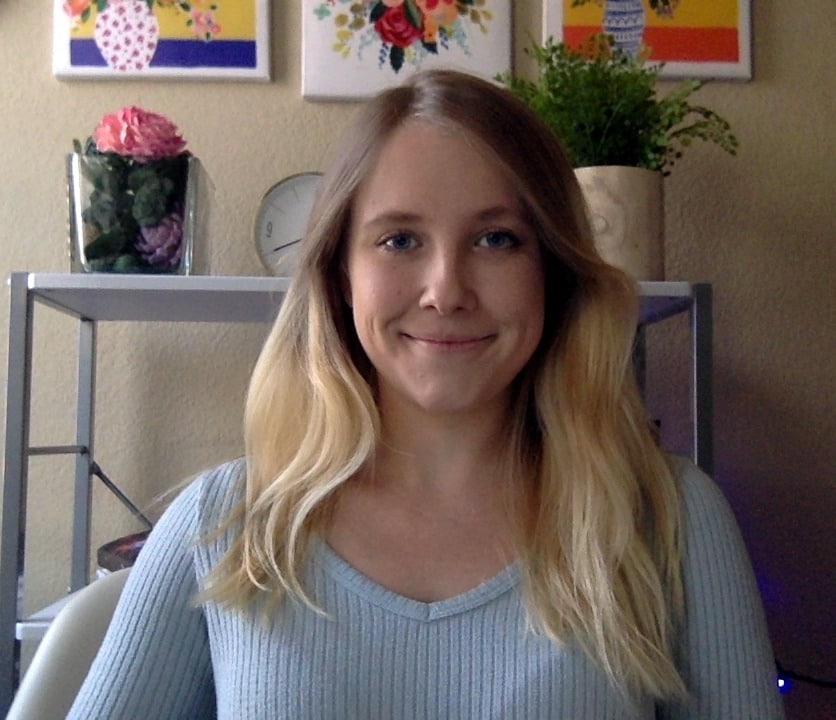 A selfie of a young blonde woman wearing a thing blue sweater.