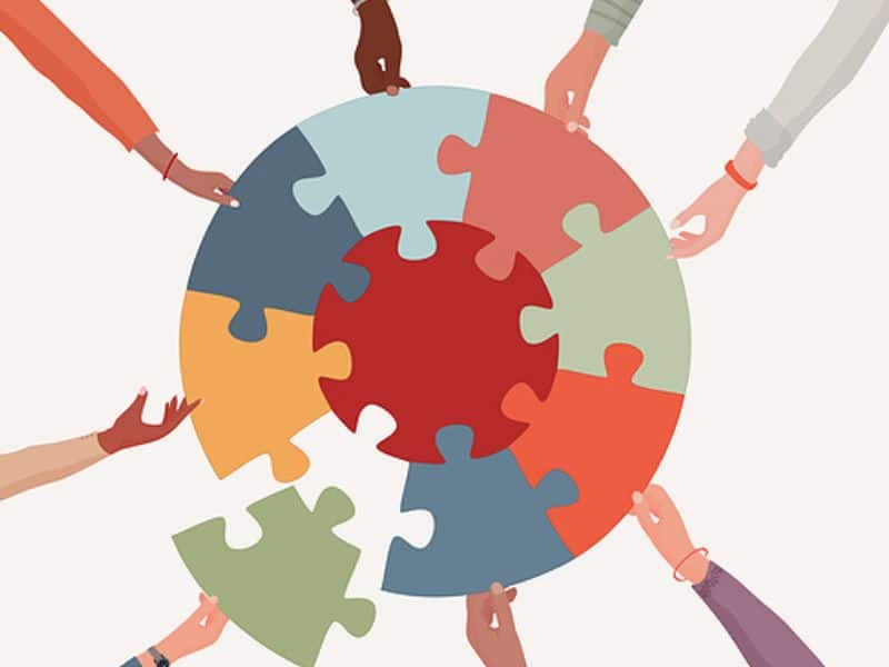 A graphic of a circular puzzle and cartoon hands each grasp one piece around the puzzle.