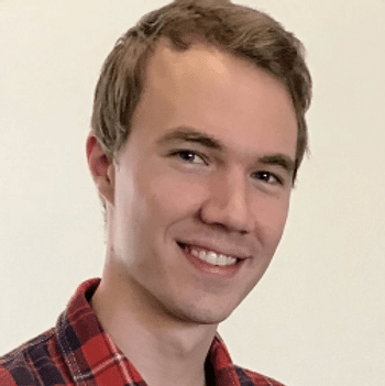 A headshot of a young white man wearing a red plaid shirt.