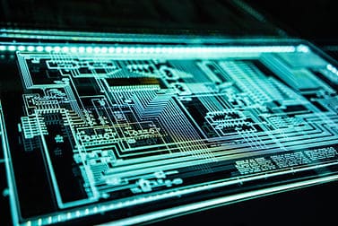 A neon blue lit board showing blueprints of a semiconductor.