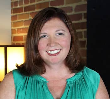 A headshot of a woman with brown hair and a turquoise tank top.